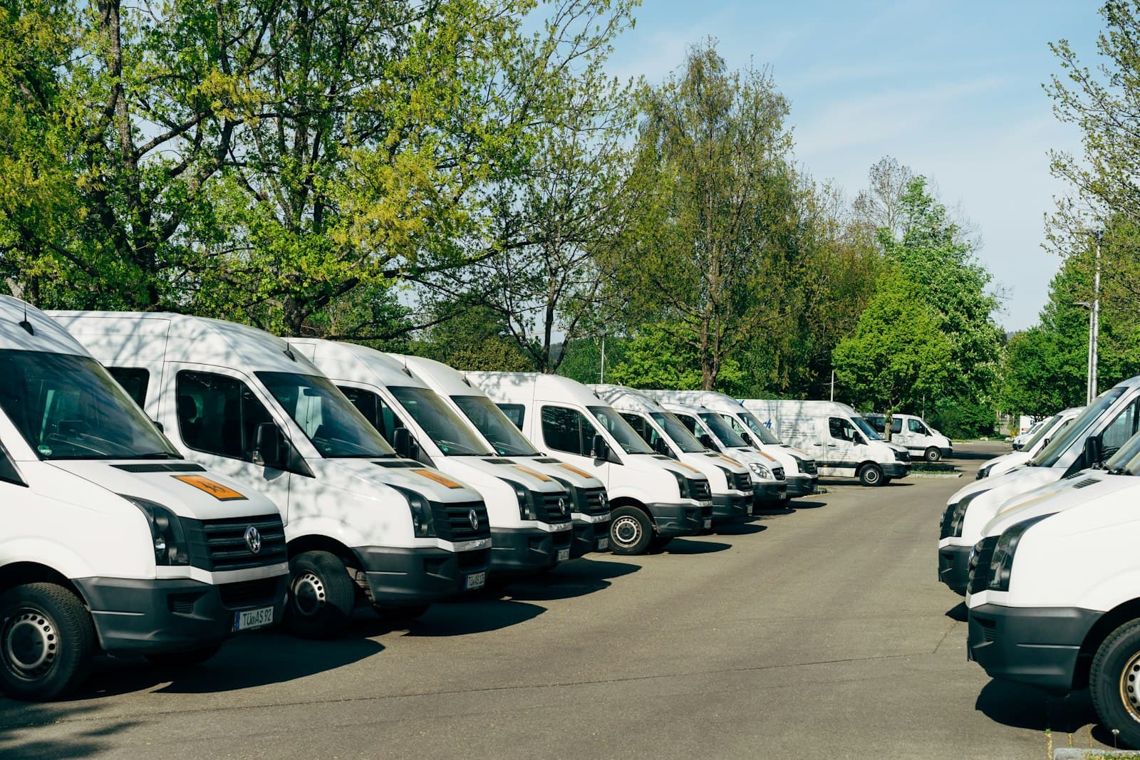 A row of commercial vans parked in a lot