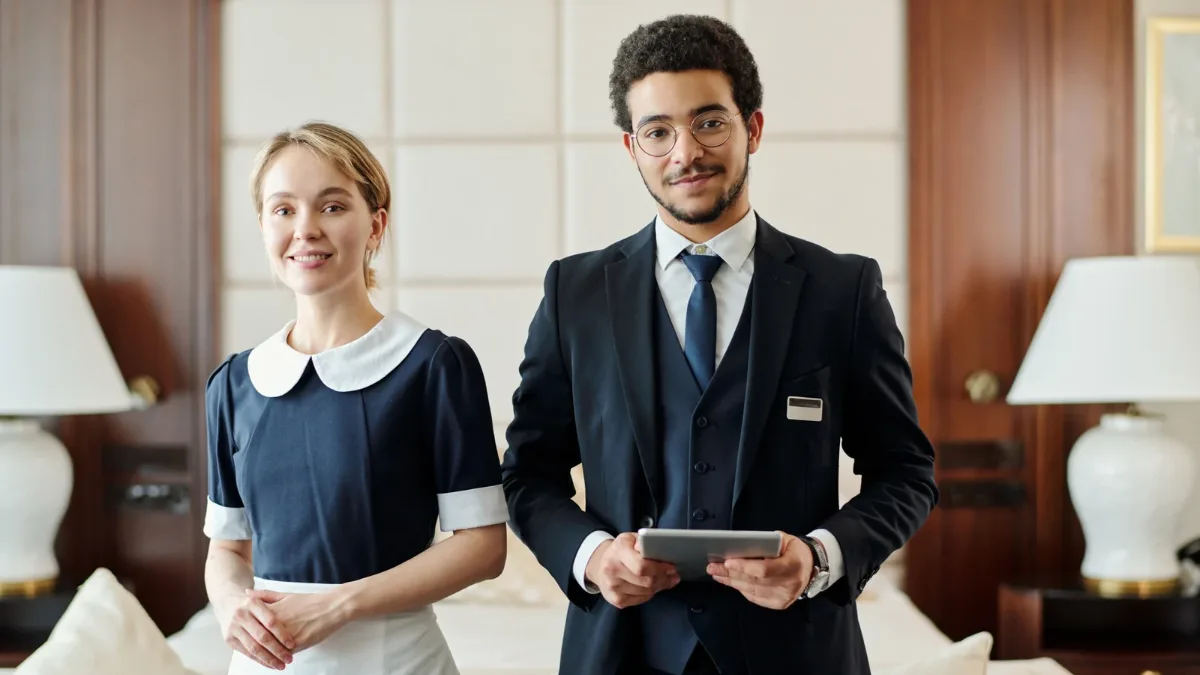 A hotel receptionist assisting a guest at the front desk A hotel receptionist assisting a guest at the front desk