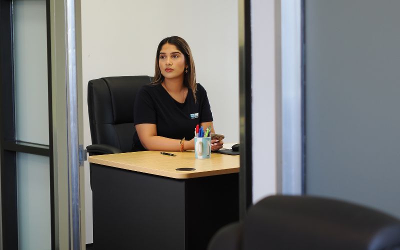 Niki Pokala – A confident General Manager making decisions in an office setting.